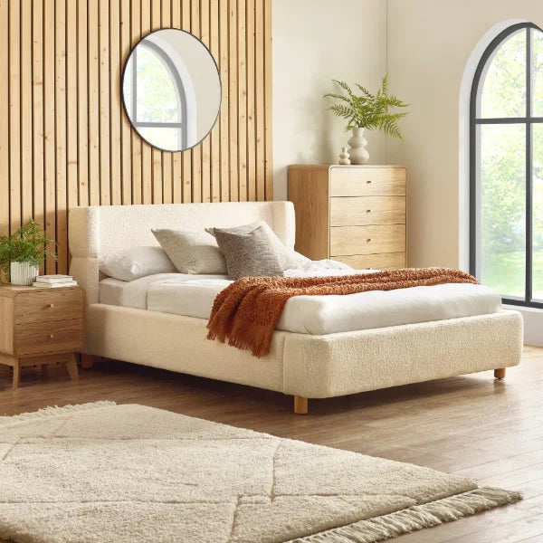Oberon cream bouclé upholstered bed with curved padded headboard in a modern bedroom setting