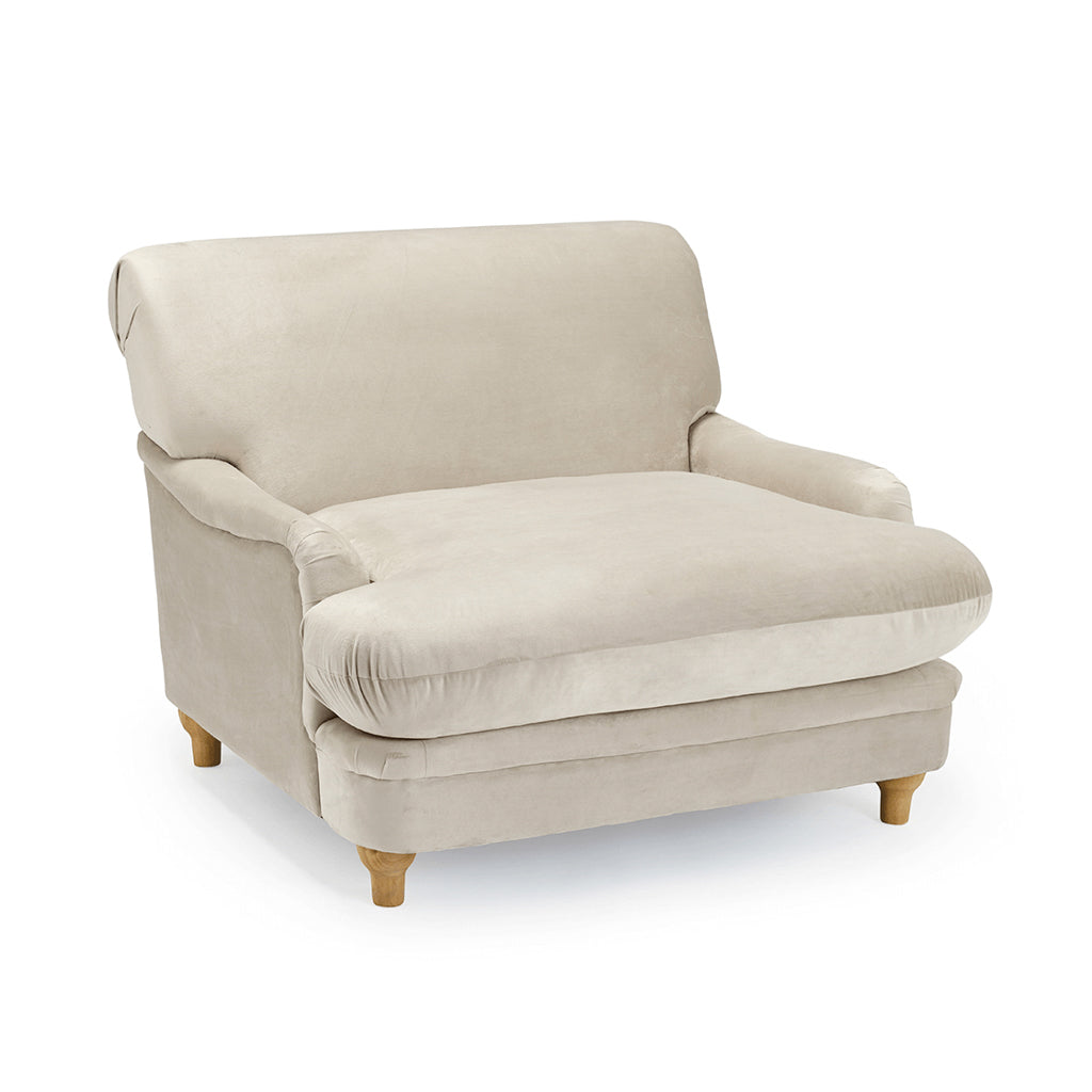 LPD Furniture Plumpton beige velvet armchair with wide cushioned seat in a modern living room setting