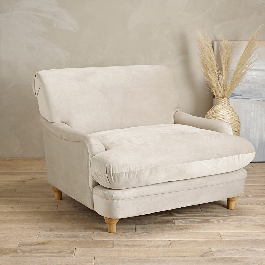 LPD Furniture Plumpton beige velvet armchair with wide cushioned seat in a modern living room setting