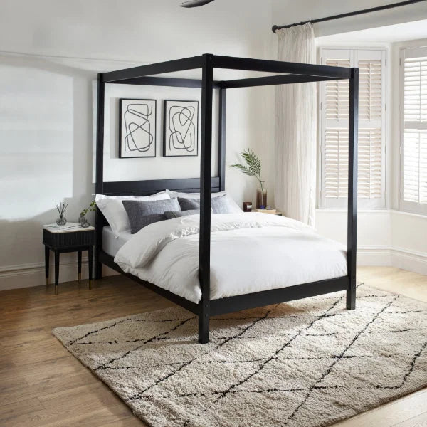Roxanne black canopy bed with tall open four-poster frame in a modern bedroom setting