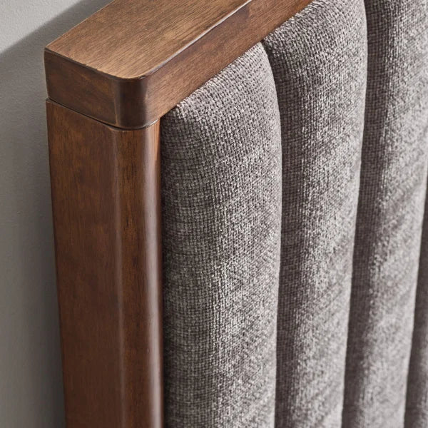 Whitmore upholstered double bed with vertical stitched headboard and walnut frame in a modern bedroom setting