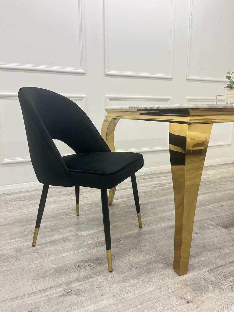 Furnish365 Astra black velvet dining chair with curved open back and gold tipped legs in a contemporary dining setting