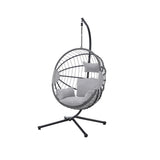 Furnish365 hanging rattan chair with PE weave and light grey cushions in a modern garden setting