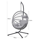 Furnish365 hanging rattan chair with PE weave and light grey cushions in a modern garden setting